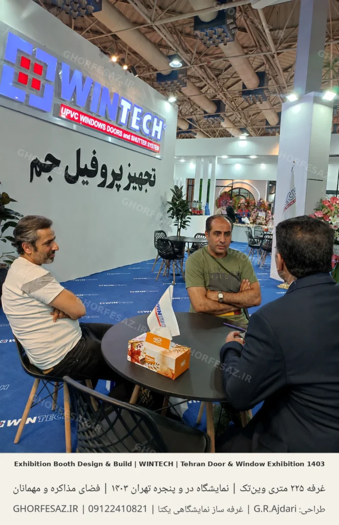 نمای فضای مذاکره غرفه وین‌تک با حضور مهمانان و میز جلسه در کنار دیوار اصلی برند؛ غرفه وین‌تک در نمایشگاه در و پنجره تهران ۱۴۰۳، نمایشگاه بین‌المللی تهران، متراژ ۲۲۵ مترمربع، تصاویر زمان برگزاری نمایشگاه